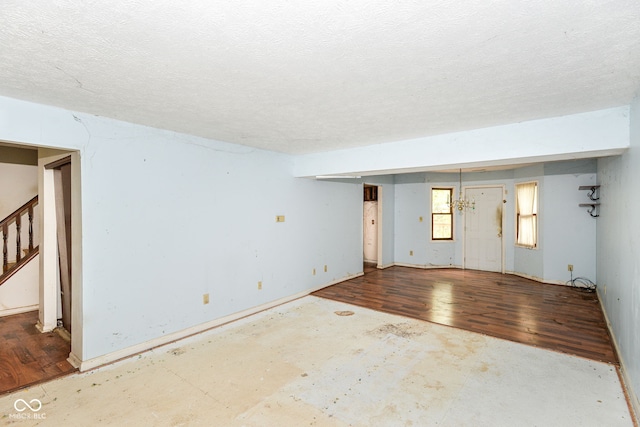 1113 Delray Dr, Indianapolis, IN 46241 - spare room featuring stairway, wood finished floors, and a textured ceiling