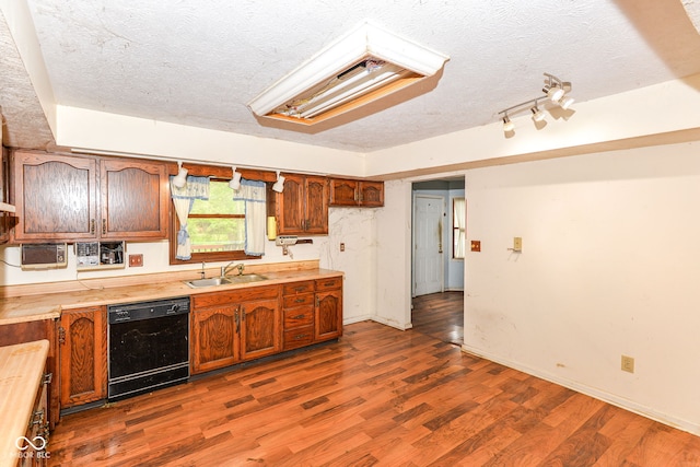 1113 Delray Dr, Indianapolis, IN 46241 - kitchen featuring dishwasher, a sink, a textured ceiling, wood finished floors, and brown cabinets