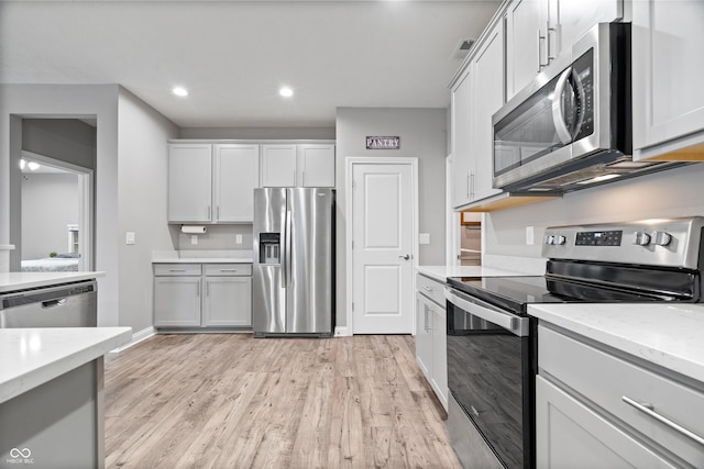 13321 N White Cloud Ct, Camby, IN 46113 - kitchen with appliances with stainless steel finishes, light wood-style floors, baseboards, recessed lighting, and light stone counters
