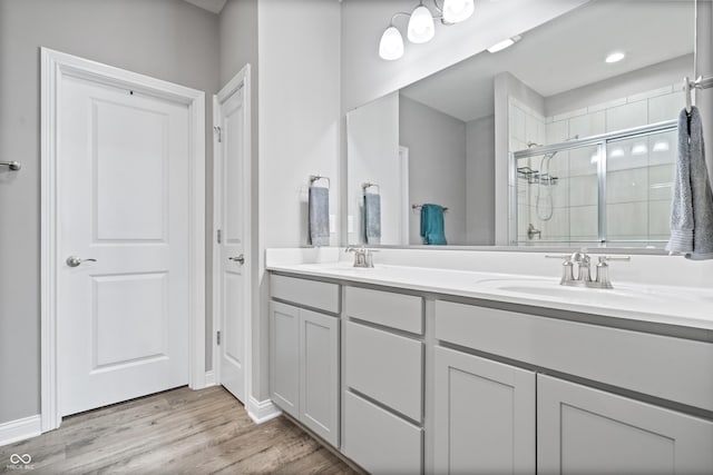 13321 N White Cloud Ct, Camby, IN 46113 - bathroom featuring double vanity, a stall shower, wood finished floors, and baseboards