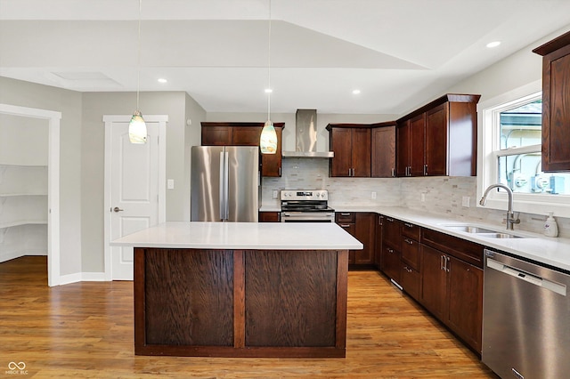126 E 86th St, Indianapolis, IN 46240 - kitchen featuring stainless steel appliances, wall chimney range hood, a sink, light wood-style flooring, and vaulted ceiling