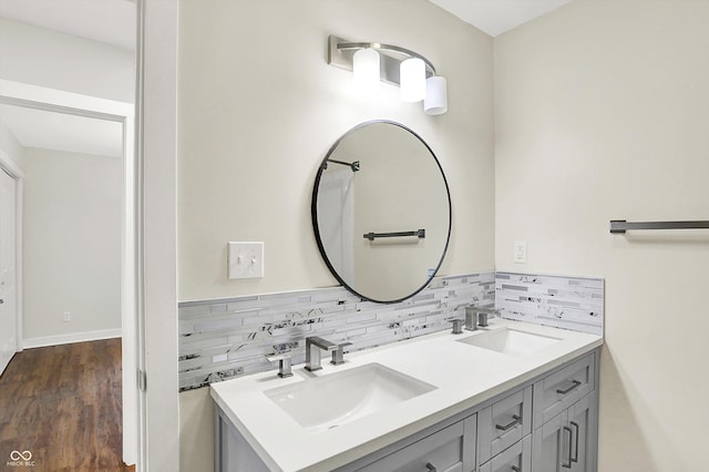 126 E 86th St, Indianapolis, IN 46240 - bathroom featuring double vanity, decorative backsplash, wood finished floors, and baseboards