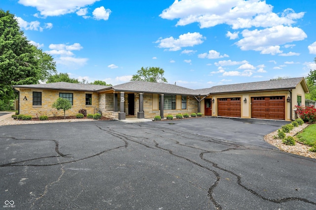 126 E 86th St, Indianapolis, IN 46240 - single story home featuring a garage, asphalt driveway, a porch, and stone siding