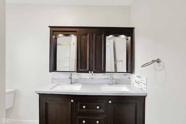 126 E 86th St, Indianapolis, IN 46240 - bathroom featuring toilet, double vanity, and backsplash