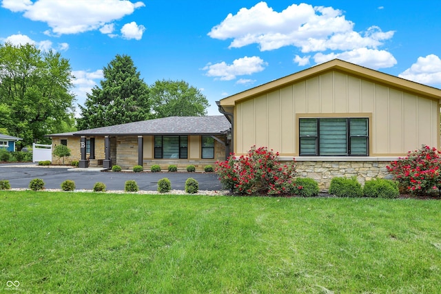 126 E 86th St, Indianapolis, IN 46240 - view of front of property featuring board and batten siding, a front lawn, and stone siding