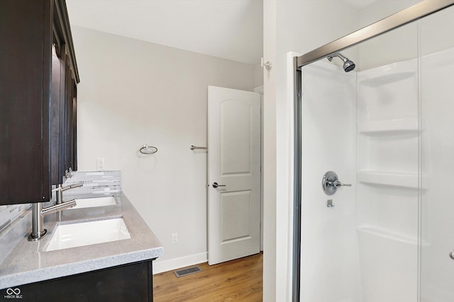 126 E 86th St, Indianapolis, IN 46240 - bathroom featuring a stall shower, wood finished floors, double vanity, and baseboards