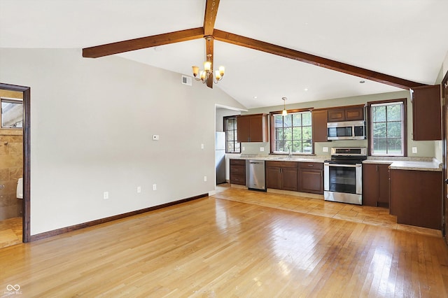 126 E 86th St, Indianapolis, IN 46240 - kitchen featuring stainless steel appliances, a sink, light countertops, a chandelier, and light wood-style flooring