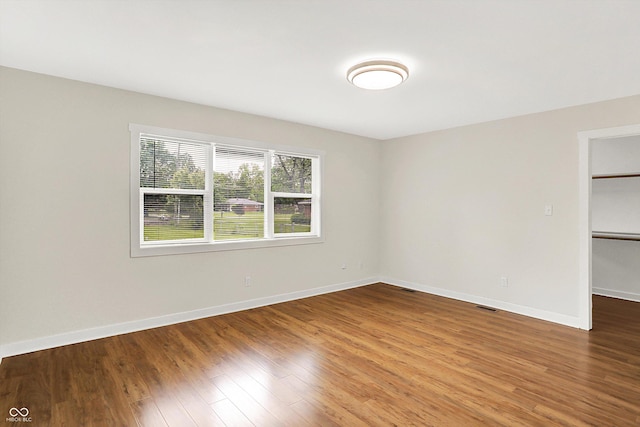 126 E 86th St, Indianapolis, IN 46240 - unfurnished bedroom featuring a walk in closet, wood finished floors, baseboards, and a closet