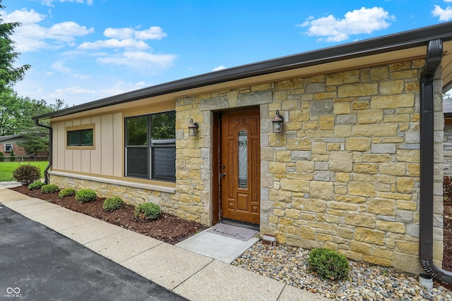 126 E 86th St, Indianapolis, IN 46240 - doorway to property with stone siding and board and batten siding