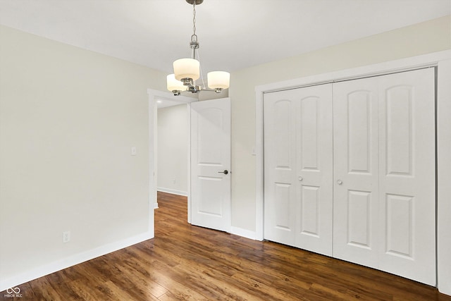 126 E 86th St, Indianapolis, IN 46240 - unfurnished bedroom featuring a chandelier, dark wood-type flooring, baseboards, and a closet