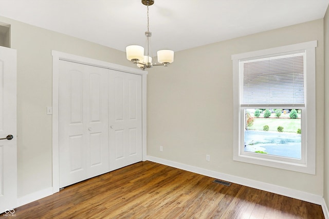 126 E 86th St, Indianapolis, IN 46240 - unfurnished dining area featuring a chandelier, wood finished floors, and baseboards