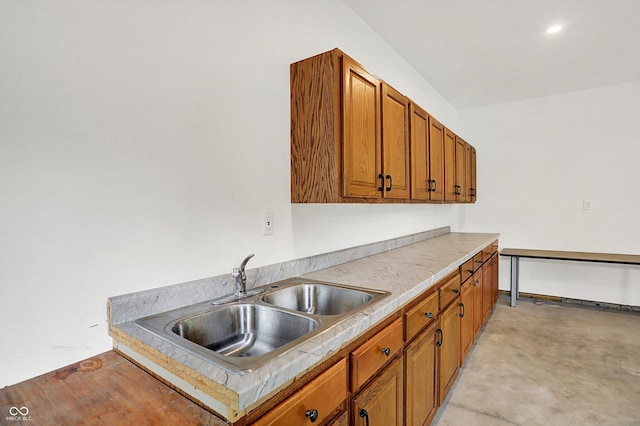 126 E 86th St, Indianapolis, IN 46240 - kitchen with a sink, brown cabinets, light countertops, and concrete flooring