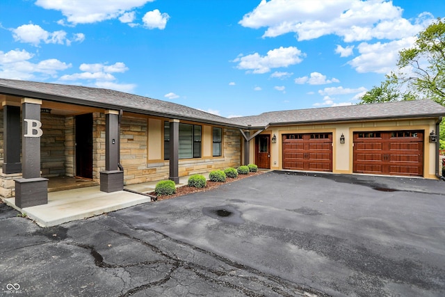 126 E 86th St, Indianapolis, IN 46240 - view of front of property with stone siding, an attached garage, driveway, and a shingled roof