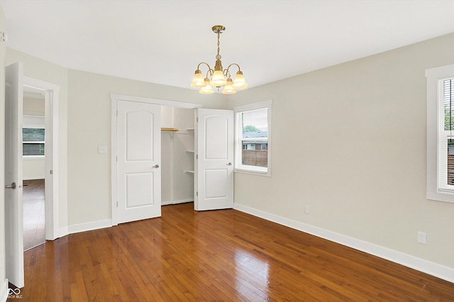 126 E 86th St, Indianapolis, IN 46240 - unfurnished bedroom with a chandelier, hardwood / wood-style flooring, baseboards, and a closet