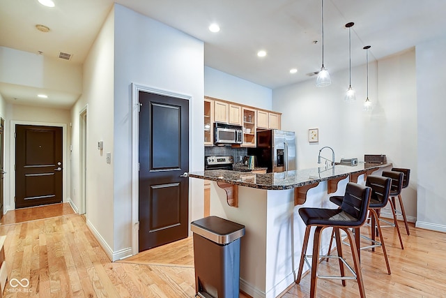 350 N Meridian St Unit A303, Indianapolis, IN 46204 - kitchen with appliances with stainless steel finishes, a kitchen breakfast bar, a peninsula, baseboards, and recessed lighting