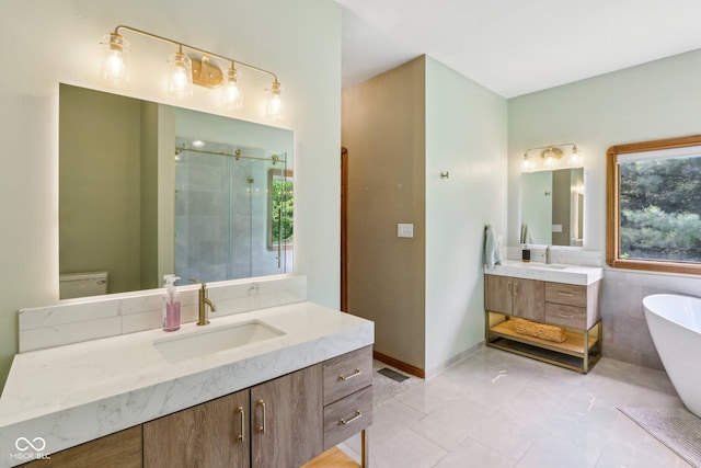 3564 Clear Creek Blvd, Martinsville, IN 46151 - bathroom with two vanities, a stall shower, a freestanding tub, tile patterned floors, and toilet