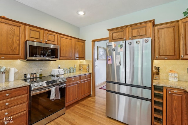 3564 Clear Creek Blvd, Martinsville, IN 46151 - kitchen with appliances with stainless steel finishes, brown cabinetry, light wood-style floors, tasteful backsplash, and wine cooler