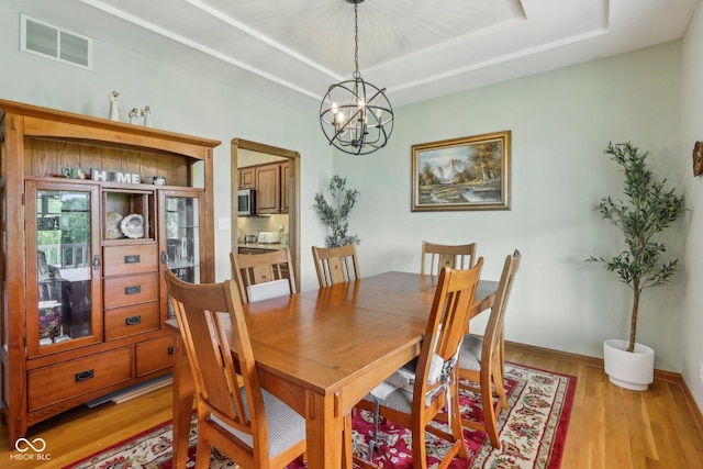 3564 Clear Creek Blvd, Martinsville, IN 46151 - dining room with a raised ceiling, light wood-style floors, a chandelier, and baseboards