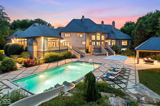 11101 Hawthorn Rdg, Fishers, IN 46037 - pool at dusk with stairs, a patio area, an outdoor pool, and a gazebo