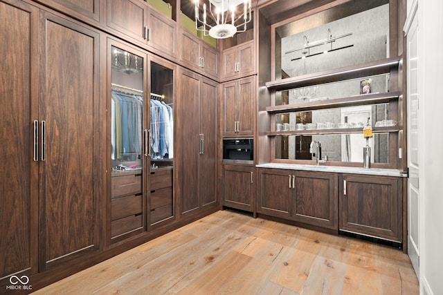11101 Hawthorn Rdg, Fishers, IN 46037 - walk in closet with light wood-style flooring and wet bar