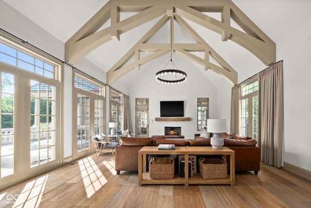 11101 Hawthorn Rdg, Fishers, IN 46037 - living room featuring high vaulted ceiling, a fireplace, light wood finished floors, and a chandelier