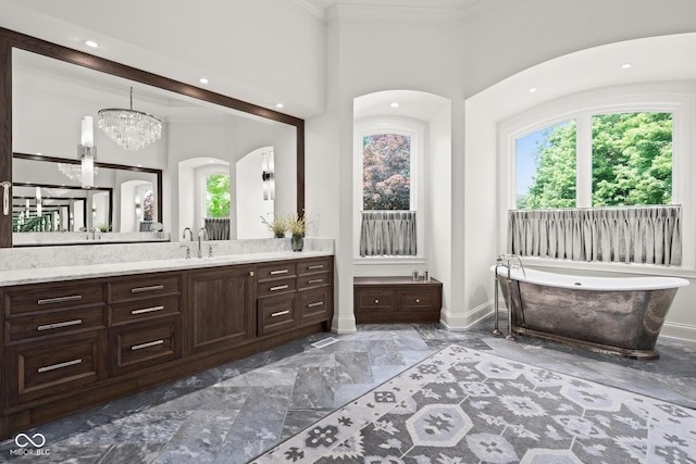 11101 Hawthorn Rdg, Fishers, IN 46037 - bathroom with vanity, marble tiled floors, healthy amount of natural light, a freestanding bath, and crown molding