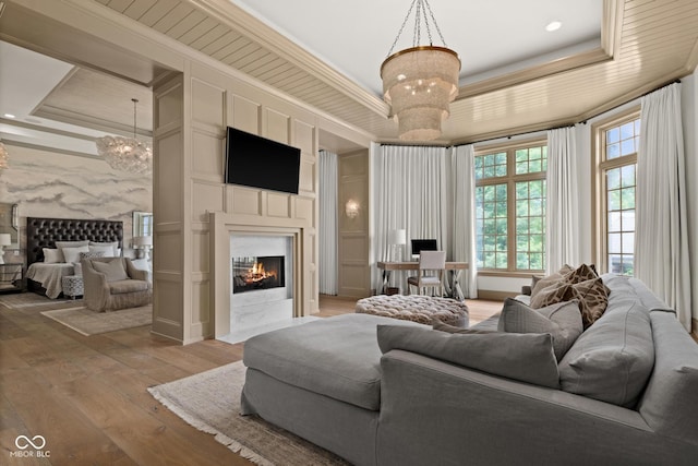 11101 Hawthorn Rdg, Fishers, IN 46037 - living area featuring a tray ceiling, a chandelier, a high end fireplace, light wood-type flooring, and crown molding