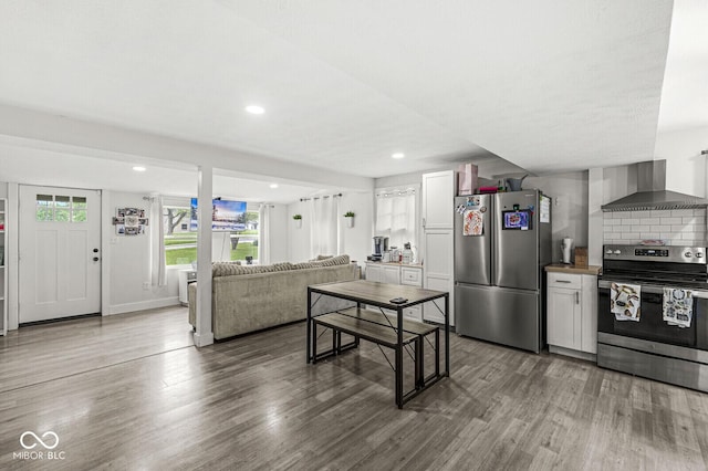 2 S 25th Ave, Beech Grove, IN 46107 - kitchen featuring appliances with stainless steel finishes, wall chimney range hood, wood finished floors, recessed lighting, and open floor plan