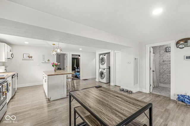 2 S 25th Ave, Beech Grove, IN 46107 - kitchen with stacked washer / dryer, butcher block countertops, light wood-type flooring, white cabinets, and stainless steel appliances