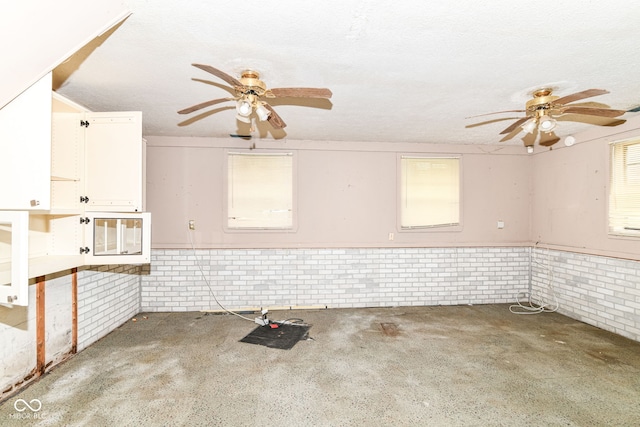 6238 E 43rd St, Indianapolis, IN 46226 - kitchen featuring ceiling fan, brick wall, wainscoting, and white cabinetry