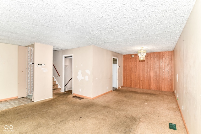 6238 E 43rd St, Indianapolis, IN 46226 - unfurnished room featuring stairs, carpet flooring, wooden walls, and a chandelier