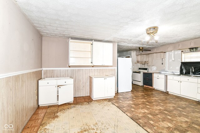 6238 E 43rd St, Indianapolis, IN 46226 - kitchen with white appliances, a textured ceiling, wainscoting, white cabinets, and a sink