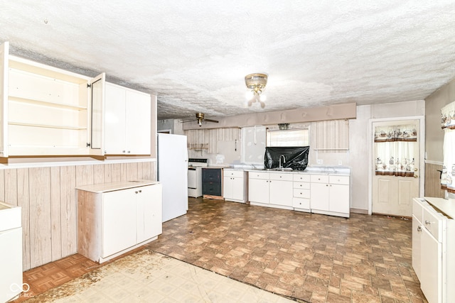 6238 E 43rd St, Indianapolis, IN 46226 - kitchen featuring white appliances, light countertops, a sink, white cabinetry, and wood walls