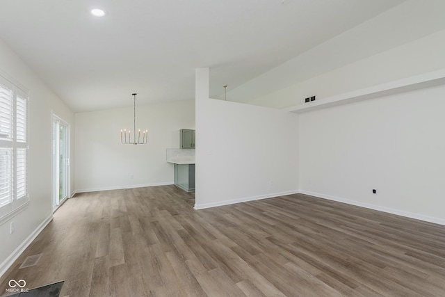 374 Pomona Ct, Greenfield, IN 46140 - spare room featuring wood finished floors, a chandelier, lofted ceiling, baseboards, and recessed lighting