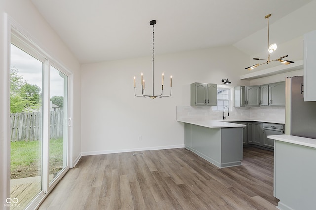 374 Pomona Ct, Greenfield, IN 46140 - kitchen with a chandelier, gray cabinetry, a sink, a peninsula, and light countertops