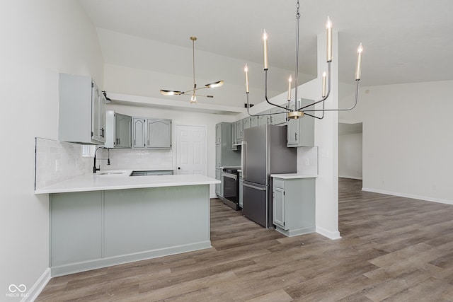 374 Pomona Ct, Greenfield, IN 46140 - kitchen featuring gray cabinets, freestanding refrigerator, stove, a peninsula, and a sink