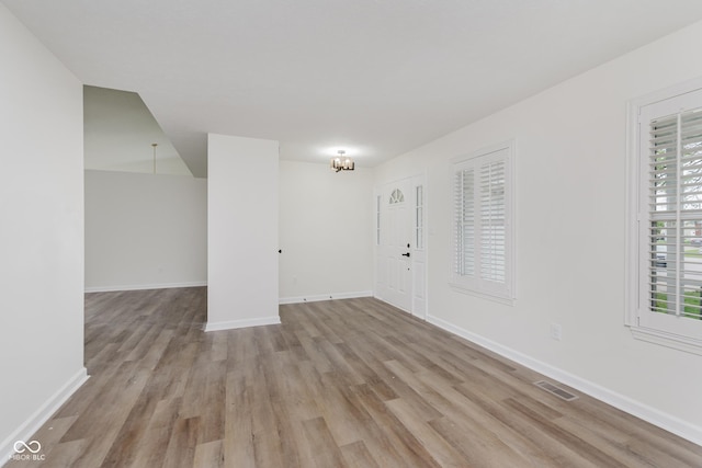 374 Pomona Ct, Greenfield, IN 46140 - empty room with light wood-style flooring, baseboards, and a chandelier