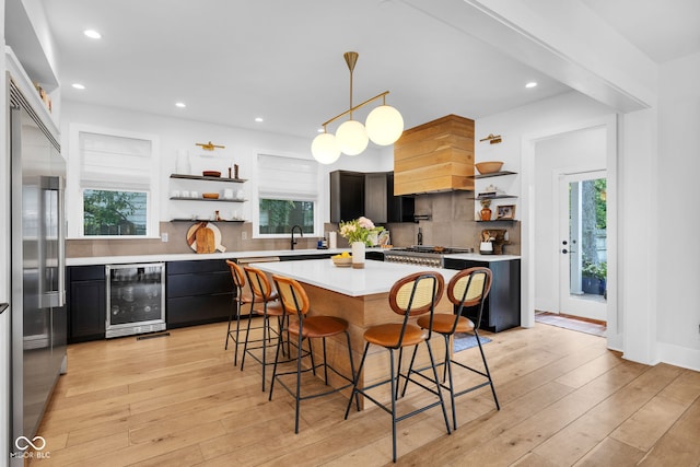 3215 N Pennsylvania St, Indianapolis, IN 46205 - kitchen with wine cooler, open shelves, stainless steel built in fridge, a breakfast bar area, and light countertops