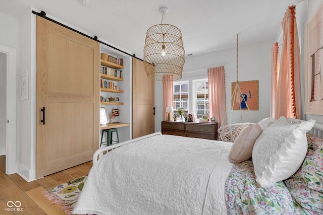 3215 N Pennsylvania St, Indianapolis, IN 46205 - bedroom featuring light wood finished floors and a barn door