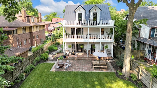 3215 N Pennsylvania St, Indianapolis, IN 46205 - rear view of house with a fire pit, a balcony, a patio area, a standing seam roof, and metal roof