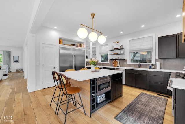 3215 N Pennsylvania St, Indianapolis, IN 46205 - kitchen with open shelves, a sink, a kitchen bar, light countertops, and a kitchen island