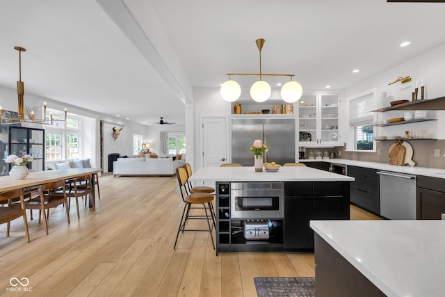 3215 N Pennsylvania St, Indianapolis, IN 46205 - kitchen with stainless steel appliances, light countertops, dark cabinetry, open shelves, and healthy amount of natural light