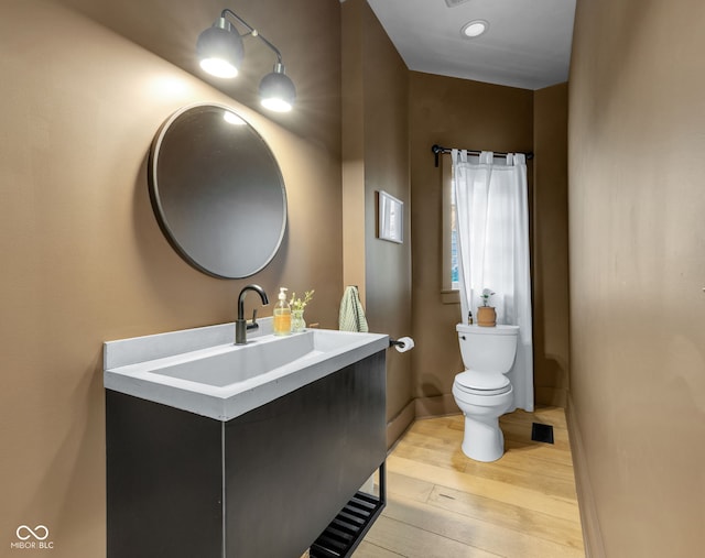3215 N Pennsylvania St, Indianapolis, IN 46205 - half bath with wood-type flooring, toilet, and vanity