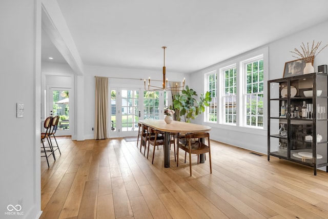 3215 N Pennsylvania St, Indianapolis, IN 46205 - dining space featuring a chandelier, plenty of natural light, light wood-type flooring, and baseboards
