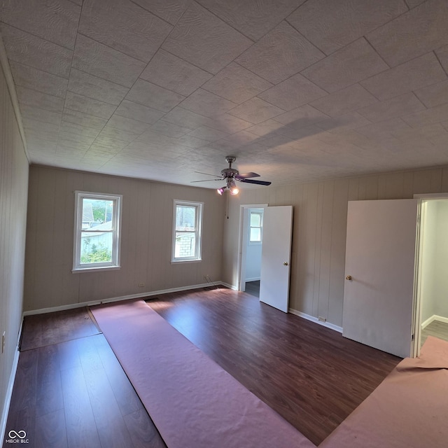 517 E Mechanic St, Brazil, IN 47834 - unfurnished living room with wood finished floors, a ceiling fan, baseboards, and wood walls