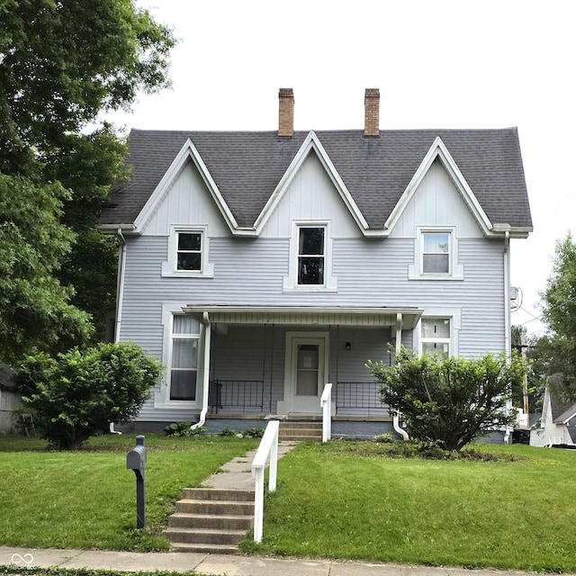 517 E Mechanic St, Brazil, IN 47834 - view of front of house with a chimney, board and batten siding, and a front lawn