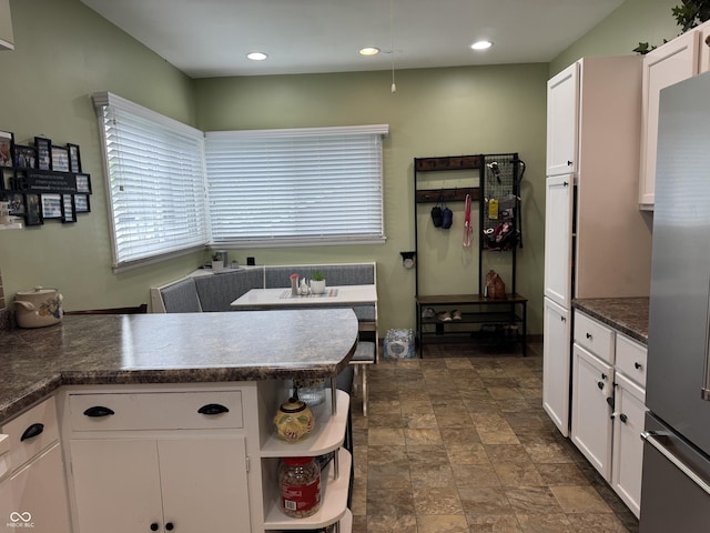 532 N Franklin St, Greensburg, IN 47240 - kitchen with white cabinets, stainless steel fridge, dark countertops, stone finish flooring, and open shelves