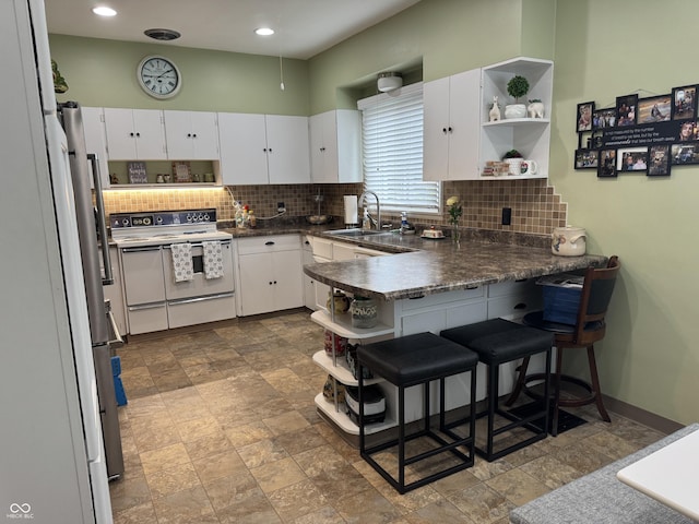 532 N Franklin St, Greensburg, IN 47240 - kitchen with open shelves, electric range, a sink, a peninsula, and tasteful backsplash