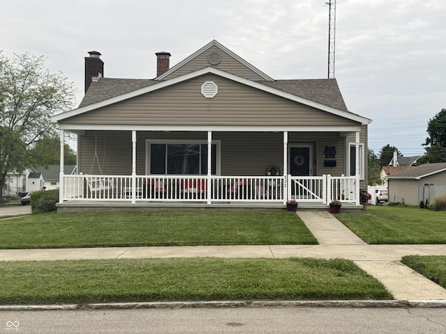 532 N Franklin St, Greensburg, IN 47240 - view of front of property with a porch, a front yard, a chimney, and a shingled roof
