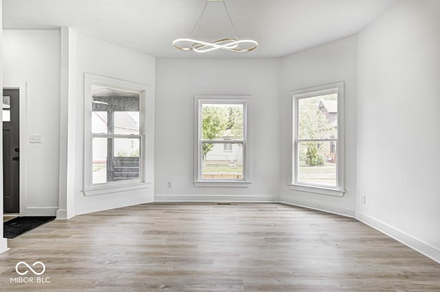 815 E 24th St E, Indianapolis, IN 46205 - unfurnished dining area featuring a chandelier, wood finished floors, and baseboards
